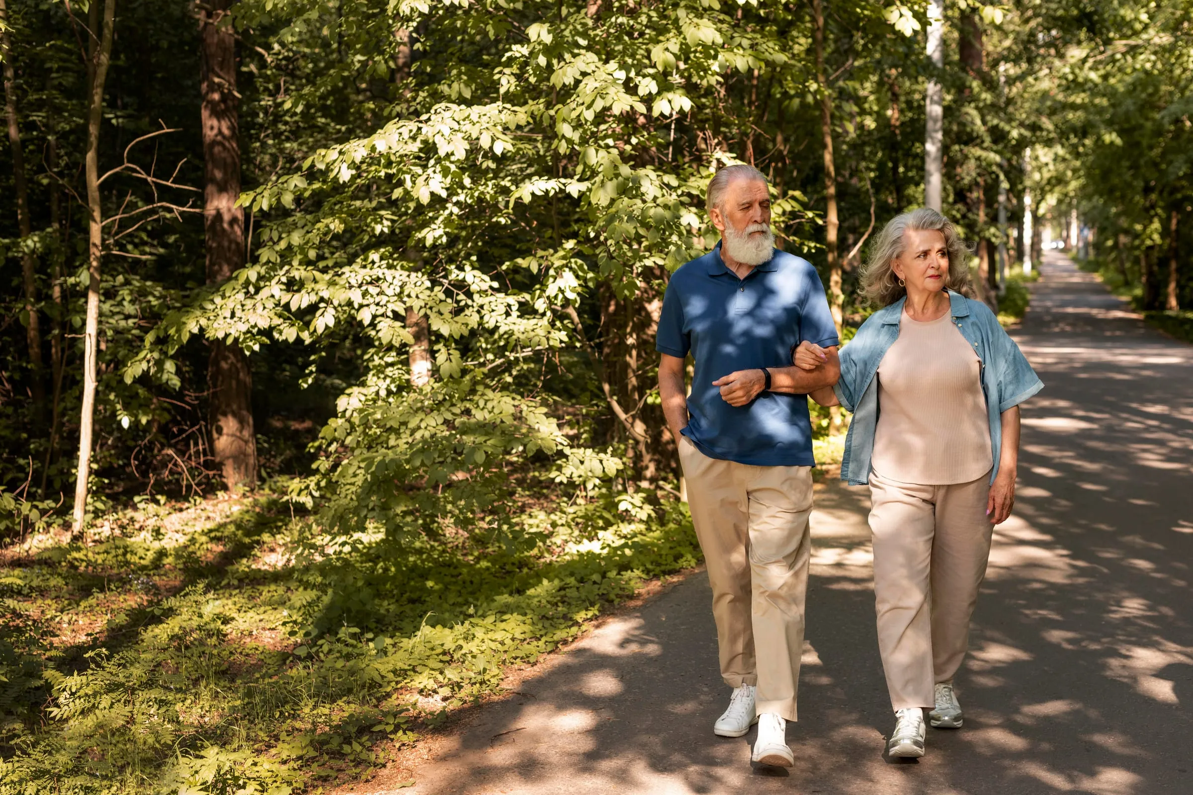 Casal idoso caminhando de mãos dadas em um parque