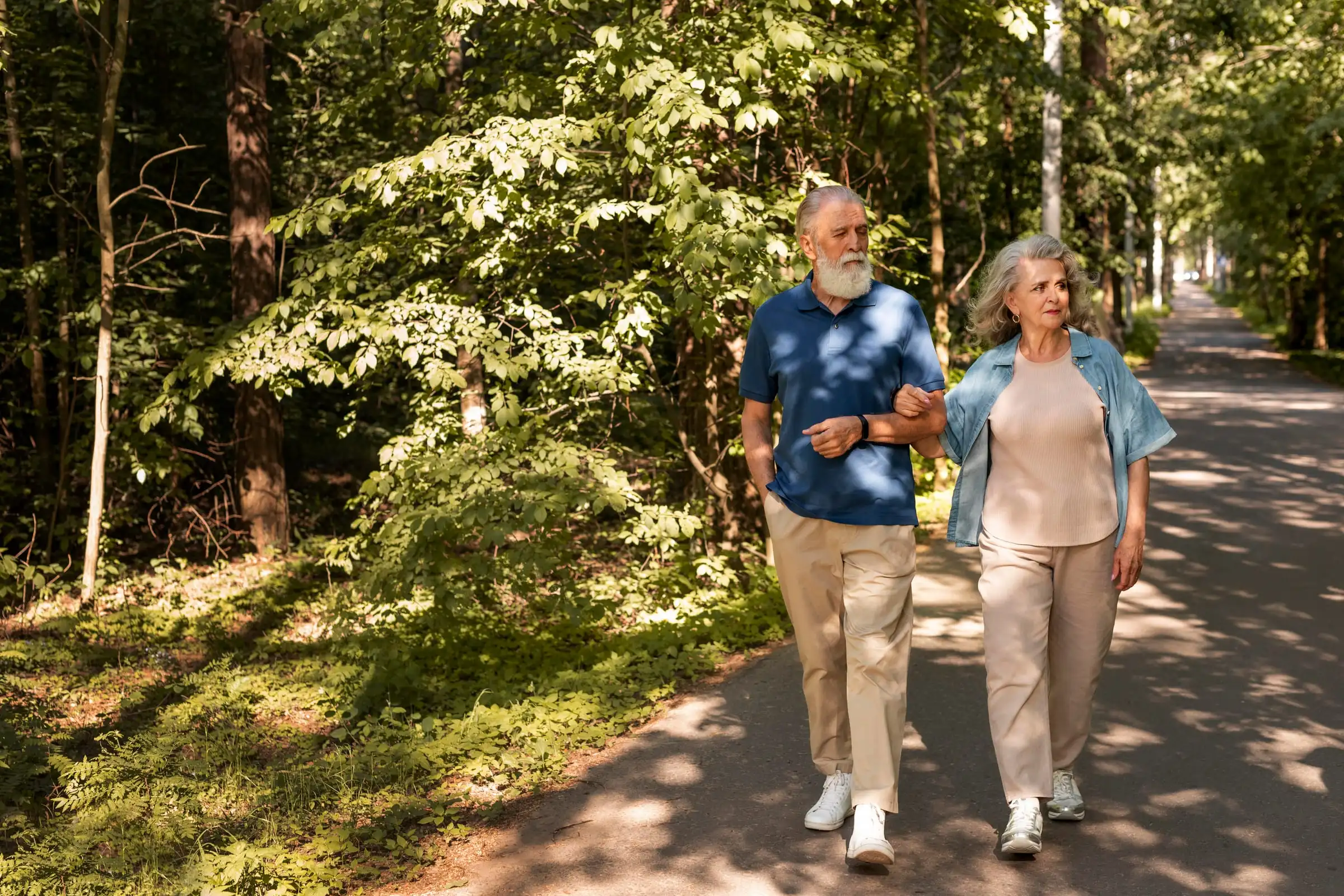 Casal idoso caminhando de mãos dadas em um parque