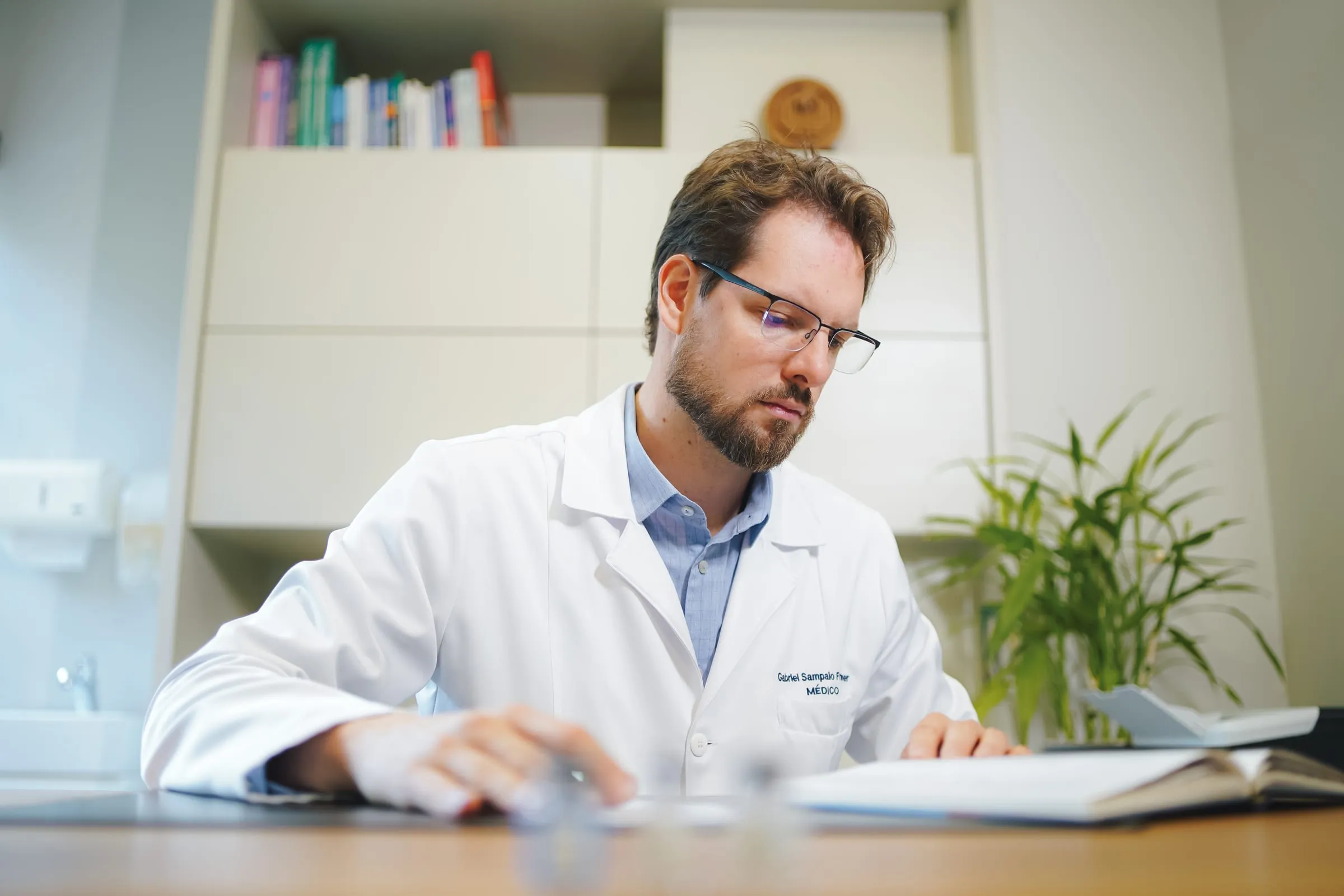 Dr. Gabriel Sampaio Froehner analisando um exame no consultório